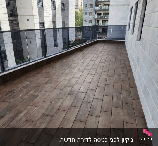מרפסת עם רצפת עץ נקייה ומבנים ברקע